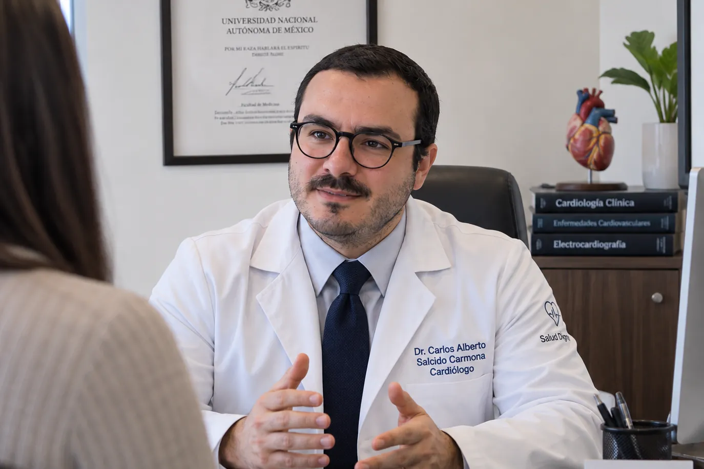 El Dr. Carlos Salcido explicando el diagnóstico a una paciente en su consultorio de Cancún